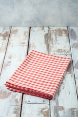 Empty wooden table with red checked tablecloth background