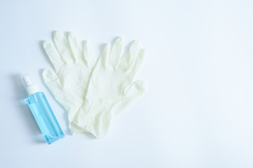 Medical gloves and sanitary alcohol spray on white background
