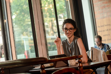 Caucacsian woman wear glasses chilling use internet on tablet in cafe during morning time