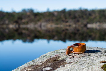 Wodden cup with coffee on a stone outdoors