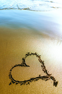 Beach. Heart painted on sea sand