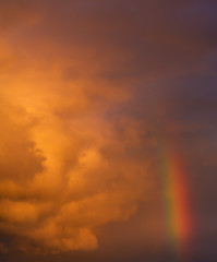 Dramatic sunset sky with clouds and a rainbow