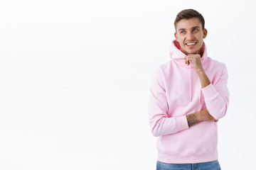 Advertisement, people and lifestyle concept. Portrait of handsome blond guy in pink hoodie smiling...