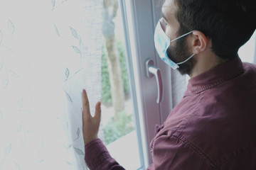 Young man is using the protective mask. Infection fear concept. Quarantine at home