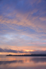 Fototapeta na wymiar sunrise over lake with mountain in distance