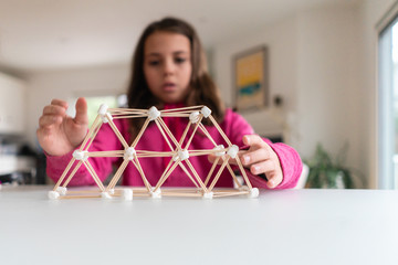Young girl building a structure for a homeschool STEM project