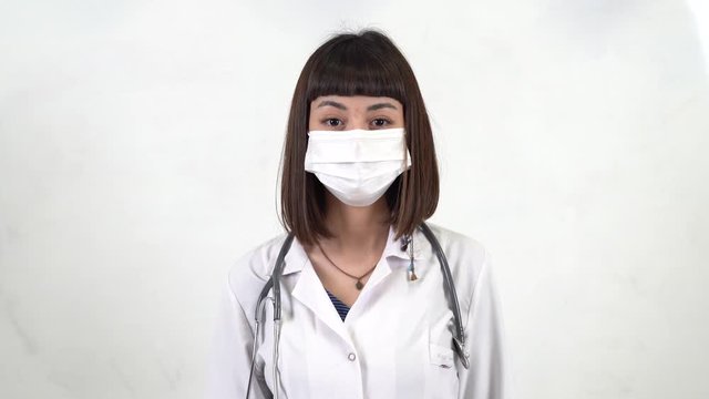 A woman doktor takes off mask and speak.