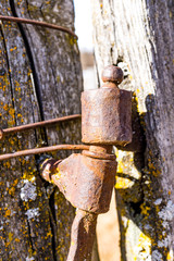 old rusty metal hinge on a wooden pale