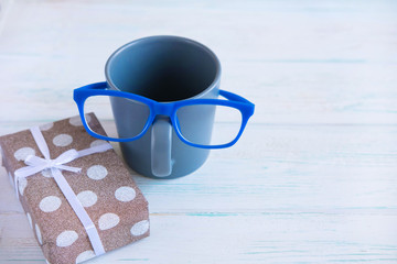 Teacher's Day. Photo concept for a birthday boy, men. Cup with glasses and a gift box.