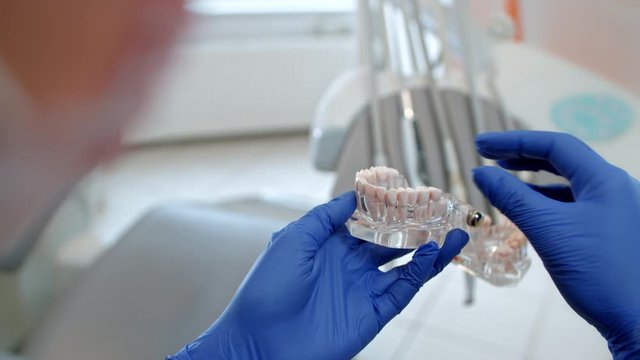 a dentist checking a model of artificial teeth in a laboratory
