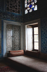 Room corner in Topkapi palace with sofa, wooden lattice door and Arabic calligraphy