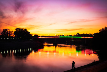 Romantic scene of  dnister river, bridge and couple standing  with a dramatic and colorful sky in the background. Tourism and holidays in Tiraspol. Transnistria, Moldova. 2020