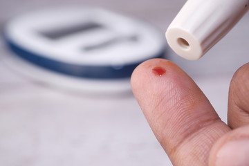close up of senior man finger measuring diabetic.