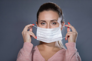 Woman puts mask on face.