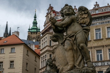 Fototapeta na wymiar Angel sculpture and St Vitus Cathedral Tower on the background, Prague