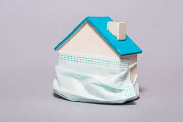 Wooden house in a protective mask, home protection