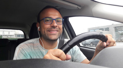Uomo alla guida dell'auto - telefonata con auricolari