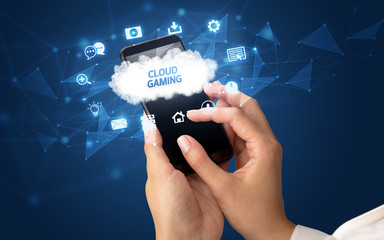 Female hand holding smartphone with CLOUD GAMING inscription, cloud technology concept