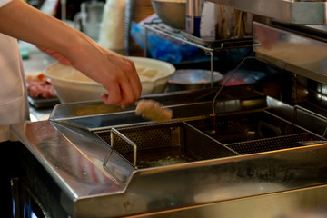 業務用フライヤーで串揚げを揚げるシーン