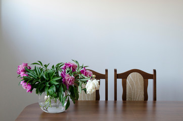 Stół z bukietem kwiatów ze ścianą na obrazy i ozdoby