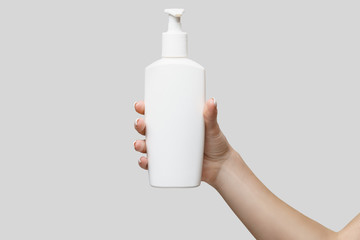 Female hands using hand sanitizer gel or liquid soap dispenser over light grey background - obrazy, fototapety, plakaty
