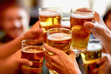 leisure, drinks, celebration, people and holidays concept - smiling friends drinking beer and...