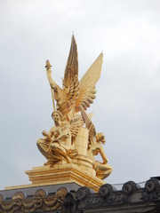 Fototapeta na wymiar Une statue en haut sur le toit du Palais Garnier