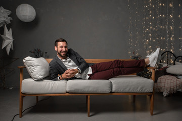 a man with a beard is laying on a bed in a jacket