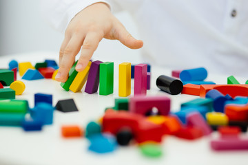 Building items in a single row. Concept of diagnostics of children's autism. A child plays with a...