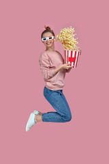 full length view of smiling caucasian woman in red-blue 3d glasses holding bucket with flying...