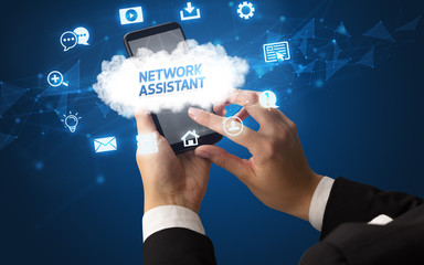 Female hand holding smartphone with NETWORK ASSISTANT inscription, cloud technology concept