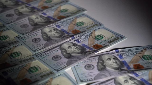 Dollar bills raked off the table in a dark room