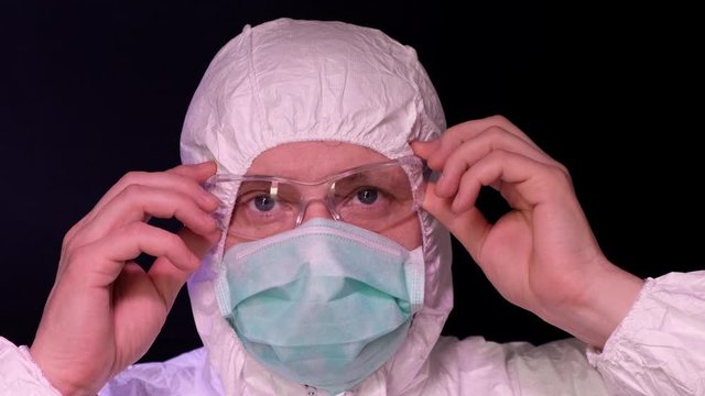 Doctor take off his glasses on black background.