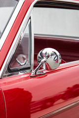 Chrome mirror of an old red car