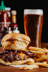 Mouth-watering bacon and angus beef burger flavored with crunchy fried onion, adding freshly cut potato fries on the side recommended for meat lovers.