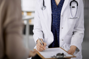 Doctor and patient discussing current health examination while sitting in clinic. Perfect medical...