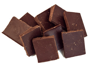 squares of dark chocolate stand one after the other in a scattering
