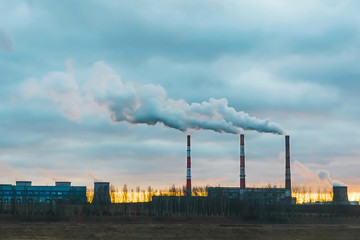 Fototapeta na wymiar Environmental pollution, environmental problems, smoke from the pipes of an industrial enterprise or a thermal power plant against a dark evening sky and sunset