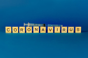 The Concept Of Coronavirus. Prevent or stop the spread of COVID-19 worldwide. Wooden letters on a blue background