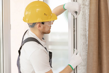 Worker in installing rubber seals on plastic upvc window