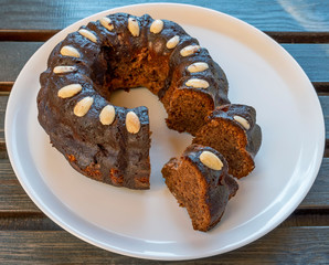 The delicious homemade cake called Bundt, on a white ceramic plate over a wooden table