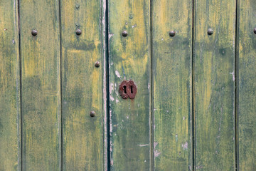 Fototapeta premium Green, wooden, vintage background with keyhole. 