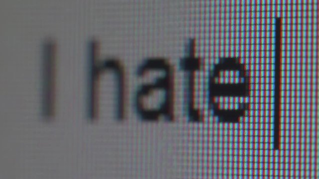 Macro view of screen and pixels and typing phrase I hate you