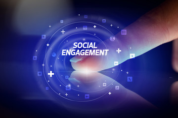 Finger touching tablet with social media icons and SOCIAL ENGAGEMENT