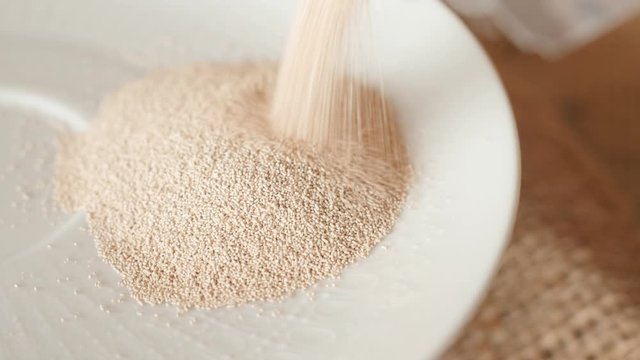 spilling pouring dry instant yeast on white plate