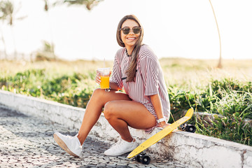 Portrait of skater woman on the beach enjoying a sunny day