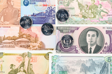 Seven North Korea Won coins with animals on a different banknotes background. DPRK money close-up macro.