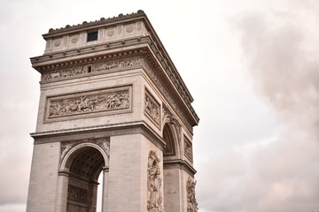 Fototapeta na wymiar Arc de Triomphe with smoke in the background on an overcast day in Paris France