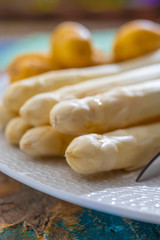 Ingredients for spring vegetarian dinner, high quality Dutch white asparagus, washed and peeled on board, ready to cookand and young potatoes