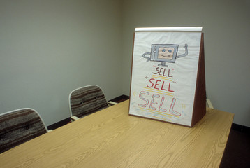 Flip chart drawing on table saying sell sell